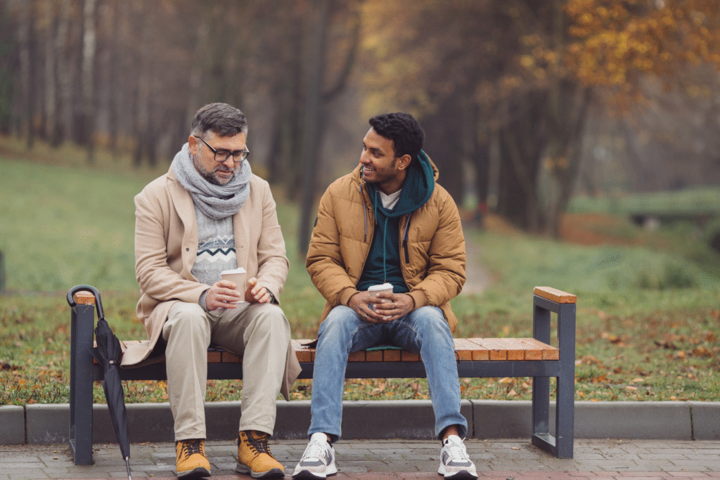 Midlife man sitting with a trusted friend, sharing a calm conversation